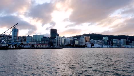 Die-Wellington-Capital-Skyline-Von-Bürogebäuden-Am-Wasser-Mit-Schönem-Düsteren-Sonnenuntergang-über-Dem-Hafen,-Nordinsel,-Neuseeland-Aotearoa