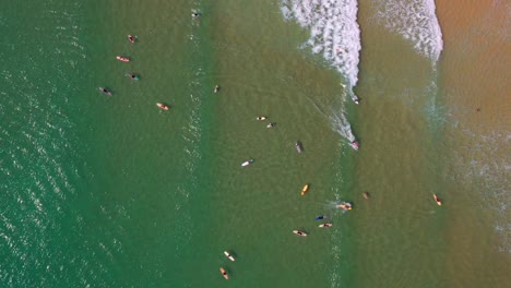 Aerial-View-Of-Surfers-Surfing-On-A-Sunny-Summer-Day-In-Noosa-Heads,-QLD,-Australia