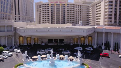 Drone-shot-rising-over-Caesars-Palace-to-reveal-Las-Vegas-skyline,-USA