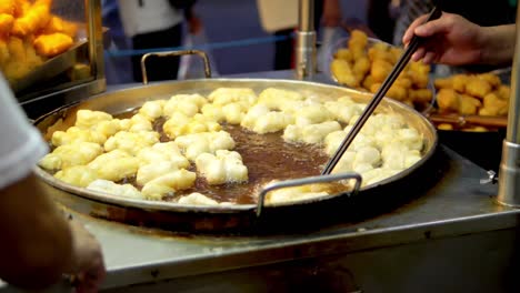 Frying-deep-fried-dough-stick-in-the-pan-at-Yaowarat-Road-Chinatown,-a-popular-travel-destination-in-Bangkok,-Thailand