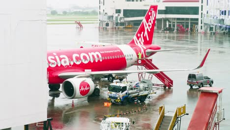 AirAsia-Airlines-dock-at-the-concourse-as-they-prepare-for-departure-with-ground-staff-around-on-a-rainy-day-at-Don-Mueang-International-Airport-DMK