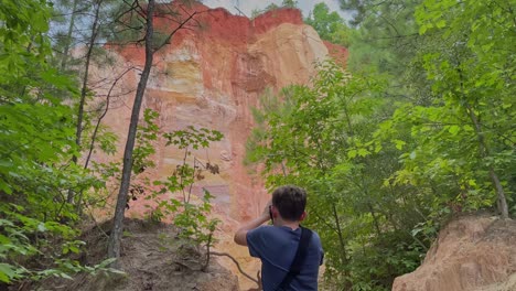 Young-photographer,-photographing-the-canyon-walls-in-Providence-Canyon-State-Park-Georgia