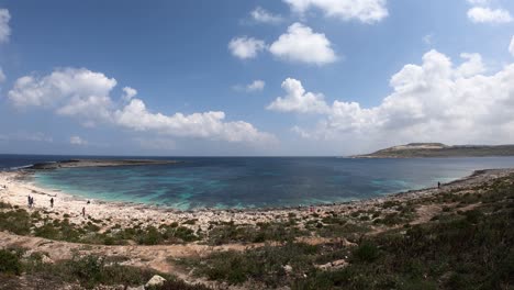 Malta-Costa-Timelapse-Giratorio-Giratorio-Vista-Fantástica-Mar-Azul-Y-Playa-De-Roca-Frente-Al-Mar,-Nubes-En-Movimiento-Rápido,-Costa-En-Forma-De-Concha