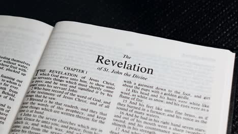 Close-Up-Shot-of-Bible-Page-Turning-to-the-book-of-The-Revelation