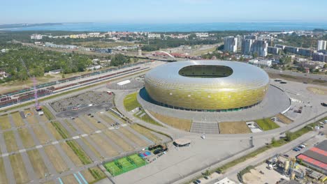 Aerial-View-of-Gdansk-Stadium-with-Baltic-Sea-in-Background-on-Clear-Summer-Day