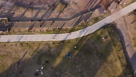 Aerial-top-down-of-cyclist-riding-on-bike-on-path-along-coastal-park-of-Buenos-Aires