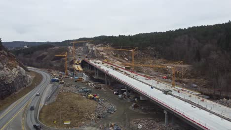 Concrete-bridge-construction-at-new-E39-highway-between-Mandal-and-Kristiansand-in-southern-Norway---Ascending-aerial-revealing-full-project-carried-out-by-company-Nye-Veier-As