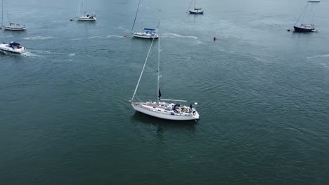 Aerial-view-following-luxury-sailboat-travelling-along-scenic-Welsh-river-estuary