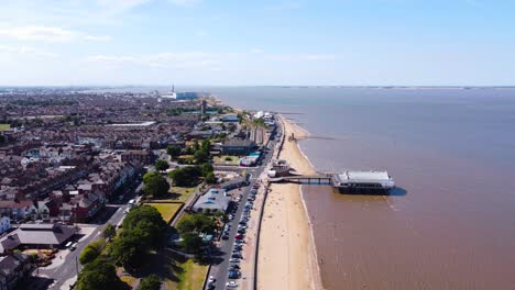 Aerial-view-down-Cleethorpes-town-coastline-towards-Grimsby-pier-seaside-tourist-attraction