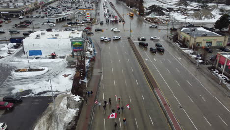 Freedom-convoy-protesters-carrying-Canadian-flags-march-down-the-middle-Highway-3