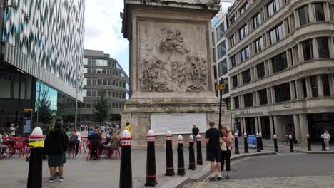 City-of-London-England-September-2022-Pan-right-establishing-shot-of-the-Fire-of-London-monument-with-tourists-below
