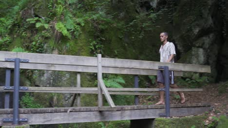 Junger-Mann,-Der-Barfuß-über-Eine-Holzbrücke-Im-Wald-Und-Tiefer-Im-Wald-Läuft