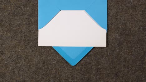 El-Sobre-De-Carta-Azul-Que-Contiene-Un-Papel-Blanco-Entra-Y-Sale-De-La-Escena-Desde-La-Parte-Superior-De-La-Pantalla