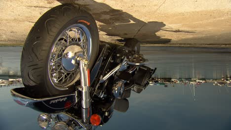 Motorbike,-Harley-Davidson-in-front-of-a-mediterranean-harbour-in-the-evening-sun-with-boats-and-sea,-tracking-shot-horizontally,-Sony-FS7,-25-fps