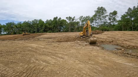 Hydraulic-excavator-removing-dirt-from-bottom-of-new-pond,-using-the-bucket-to-tamp-dirt-at-top-of-side-wall