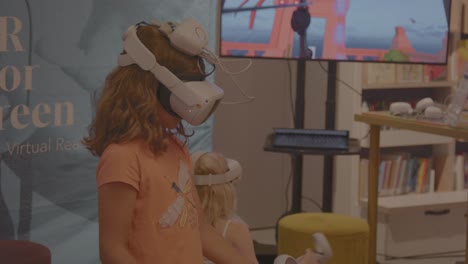 Two-young-girls-playing-and-having-fun-with-Virtual-Reality-headset