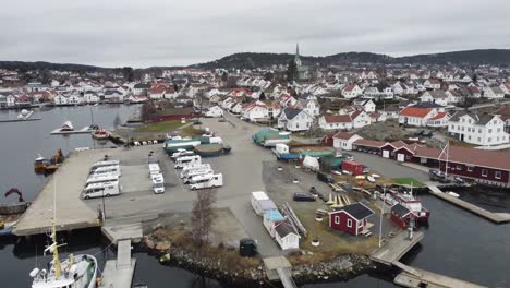 Lillesand-Noruega---Antena-En-Movimiento-Hacia-Arriba-Desde-El-Puerto-Deportivo-Y-El-Paseo-Marítimo-Hasta-La-Descripción-Completa-De-La-Ciudad-Durante-La-Mañana-Nublada