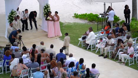 Young-ringbearer-walks-down-aisle-at-wedding-in-tropical-beach-destination