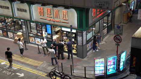 Hongkong--May-20,-2022:-workers-pass-by-in-front-of-a-cafe-after-finishing-work-at-night