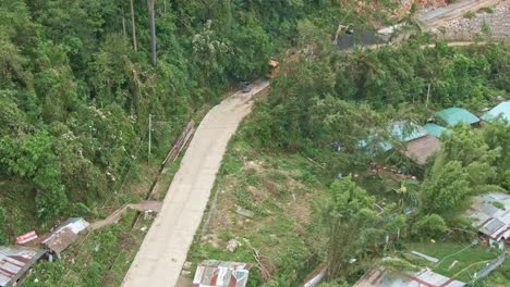 Aerial-drone-shot-of-hillside-long-highway-and-houses-from-Province-of-Puerto-Galera,-Philippines