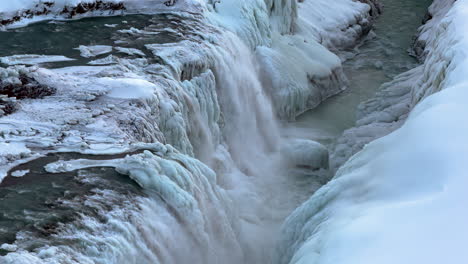 Cascada-De-Gullfoss-En-Invierno,-Cañón-Del-Río-Hvítá-Islandia,-Espectacular-Cascada-De-Flujo-De-Agua-Que-Desciende-Al-Cañón-De-Gullfossgjúfur-Rodeado-De-Hielo-Nevado-Y-Tierras-Congeladas,-Paisaje-Glacial