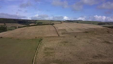 Aerial-tracking-forward-towards-St-Catherine's-Chapel,-near-Weymouth,-and-the-village-of-Abbotsbury-lies-behind-the-hill