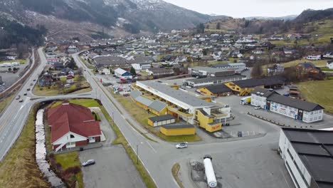 Moi-village-in-Lund-municipality-Norway---Upward-moving-aerial-revealing-small-town-and-road-in-between-mountains