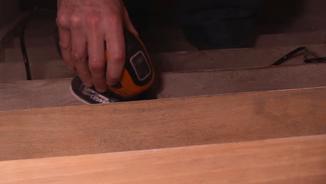 wooden-staircase-sanding-with-an-electric-tool-going-from-one-step-to-the-other