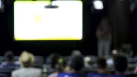 Lecture-in-auditorium,-speakerm-defocused-video,-moving-camera,-panoramic-motion
