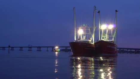 Two-Shrimp-Trawlers,-commercial-fishing-boats-docked-in-New-Bern-during-a-protest-against-regulations,-at-night,-in-North-Carolina