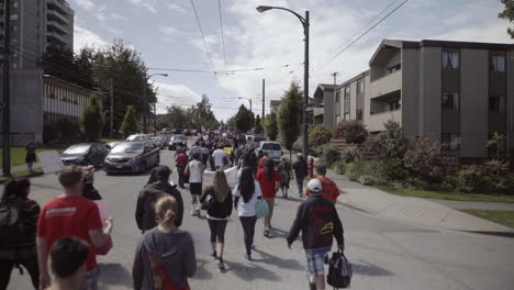 People-walking-in-streets-of-Vancouver-on-Indigenous-day,-from-behind