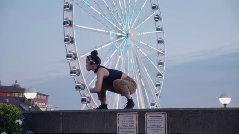 Young,-female,-contemporary-dancer-near-an-urban-Ferris-wheel