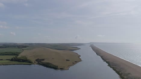 Aerial-tracking-forward-looking-east-along-the-fleet-lagoon-and-chesil-beach-at-Abbotsbury