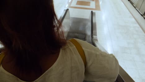 Close-up-of-a-woman-as-she-rides-down-an-escalator