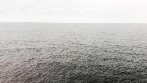 Luftaufnahme-Eines-Einsamen-Motorbootes,-Das-Durch-Die-Endlosen-Wellen-Des-Offenen-Ozeans-Rast