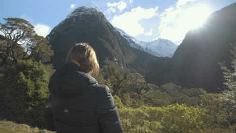 Mädchen-Fotografiert-Schneebedeckte-Gipfel-Und-Berge,-Umgeben-Von-Einem-üppigen-Wald-Und-Tal-In-Neuseeland-An-Einem-Hellen-Und-Sonnigen-Tag