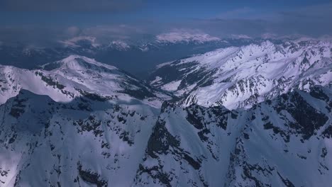 Toma-Aérea-De-Drones-Volando-Sobre-Los-Vastos-Alpes-Cubiertos-De-Nieve-Sobre-La-Ciudad-Turística-De-Verbier,-Suiza