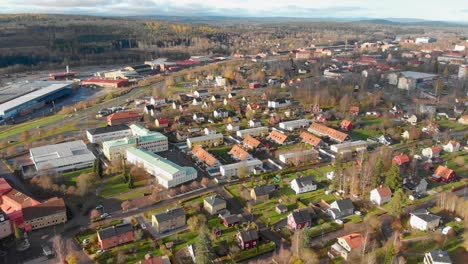 Drone-footage-panning-over-a-residential-area-and-a-school-in-a-small-town-with-some-industries-in-the-background