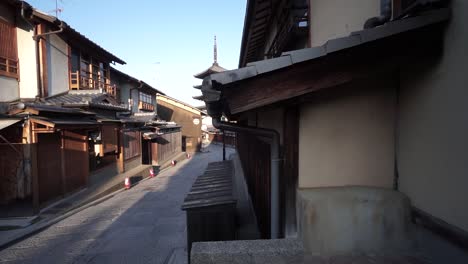Slide-to-hide-a-popular-traditional-Japanese-pagoda-in-an-empty-street-with-no-tourists-or-people-early-in-the-morning-in-Kyoto,-Japan