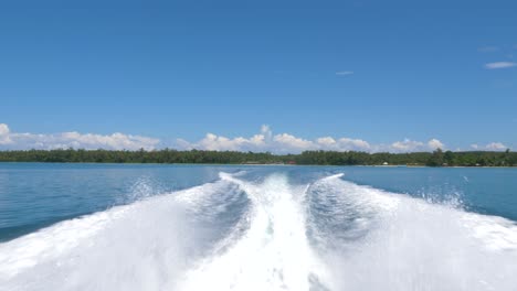 Trails-of-a-speed-boat-with-tropical-island-in-the-background