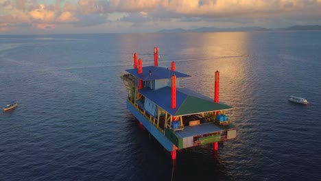 Aerial-flight-at-stunning-sunset-over-oil-platform-in-ocean-in-Mabul,-Malaysia