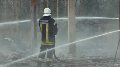 Feuerwehrleute-Richten-Wasserstrahl-Auf-Brennendes-Haus
