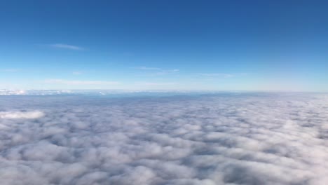Vista-Desde-La-Ventana-De-Un-Avión,-Nubes-Esponjosas-Brillantes-Y-Estratosfera-Azul-Profundo