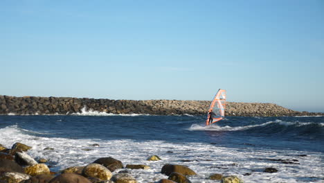 Pan-shot-of-a-norwegian-windsurfer,-surfing-a-wave-and-then-kicks-out,-falls-and-recovers,-on-the-North-sea,-in-the-atlantic-ocean,-on-a-sunny,-summer-day,-in-Lista,-South-Norway