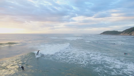 Filmische-Antenne-Bei-Sonnenaufgang-Von-Surfern-Entlang-Der-Küste-Von-Südafrika-Sport