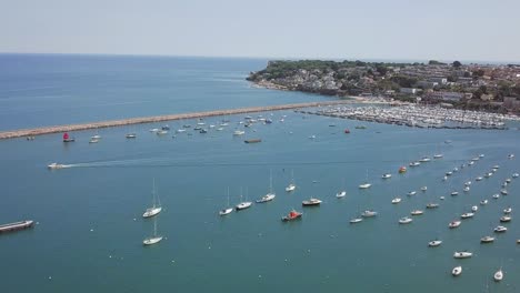 Aerial-footage-of-yachts-and-sailboats-in-port-of-a-marina-by-a-seaside-community
