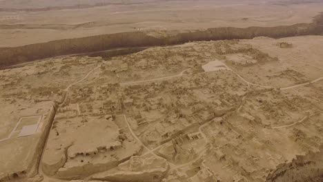 Ein-Drohnenschuss,-Der-Sich-Um-Einen-Grauen-Tag-Rückwärts-Von-Den-Ruinen-Von-Jiaohe,-Xinjiang,-Bewegt