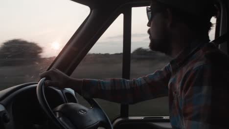 Man-drives-van-and-admires-sunset-view