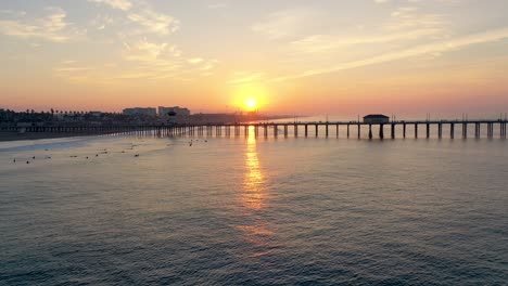 Abejón-De-4k-Sunrise-En-El-Famoso-Muelle-De-Huntington-Beach-En-Surf-City,-EE.-UU.,-Sur-De-California