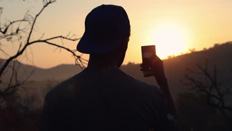 Guy-taking-photo-of-sunrise-on-cell-smart-phone